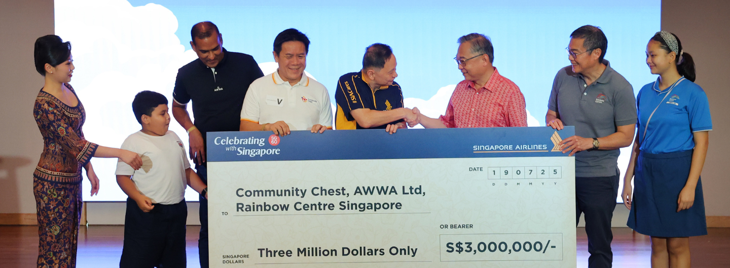People hold large Singapore Airlines check for S$3,000,000.00 to Community Chest.